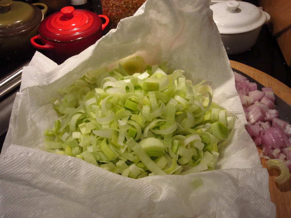 Chopped and cleaned leeks on a paper towel.