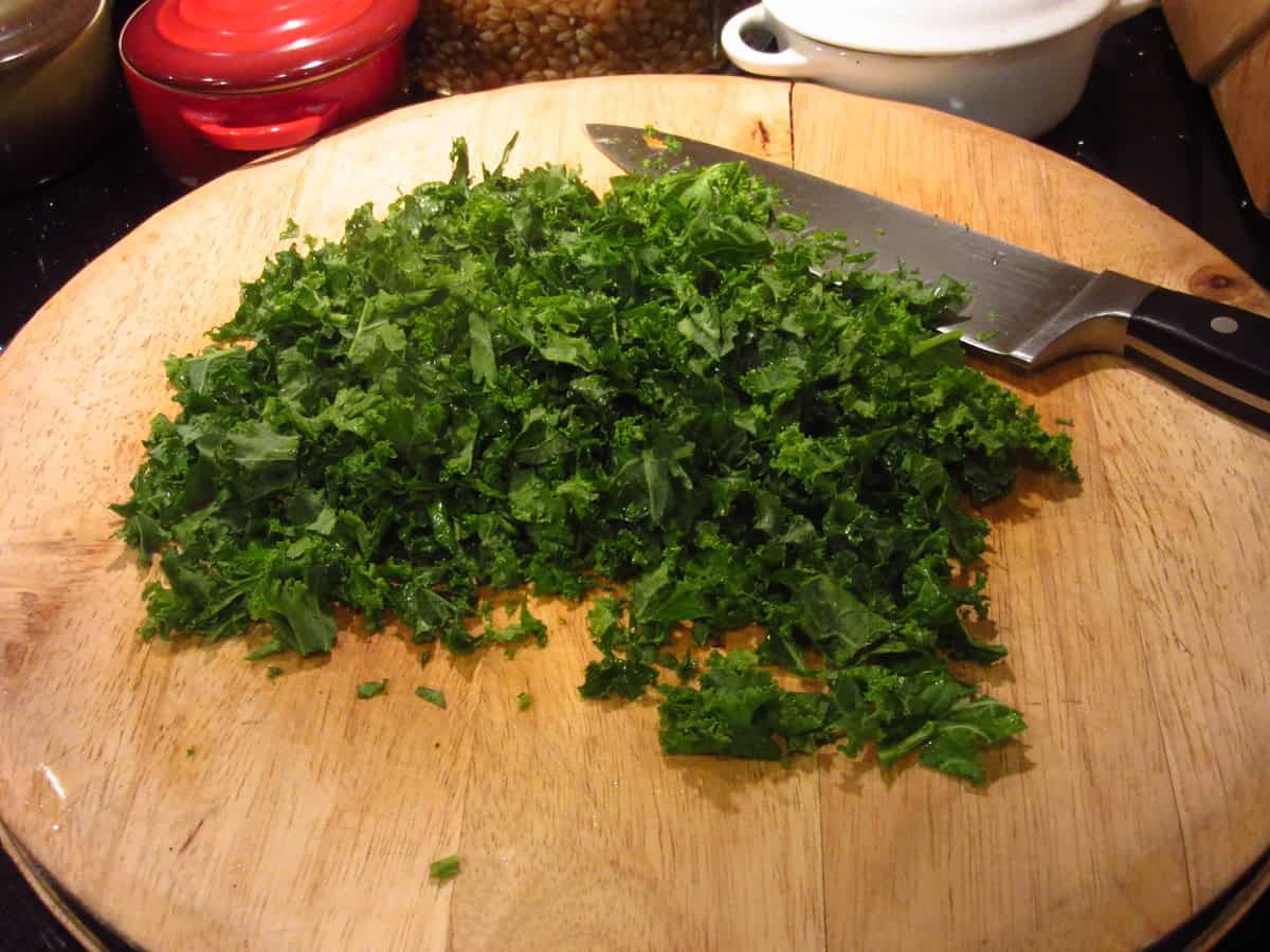 Chopped Kale on a cutting board with a knife.