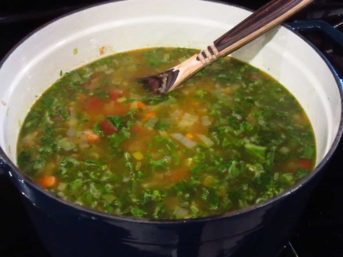Fresh kale in a stockpot of soup.