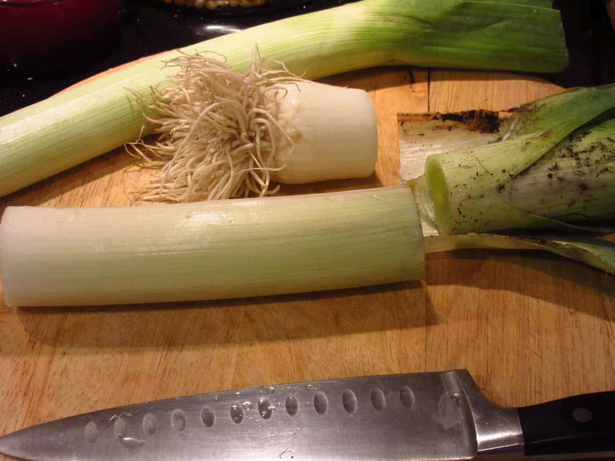 The start of cleaning leeks with a cutting board and a knife.