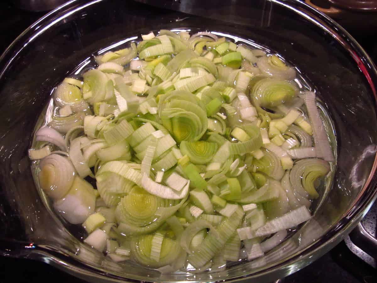 Slices of leek in a bowl of water for washing.