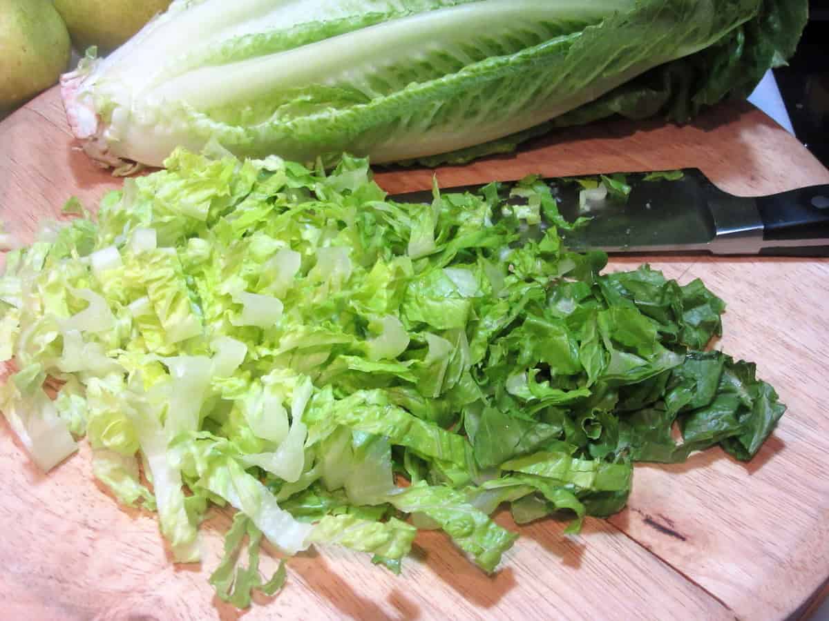 Chopped romaine lettuce on a cutting board.