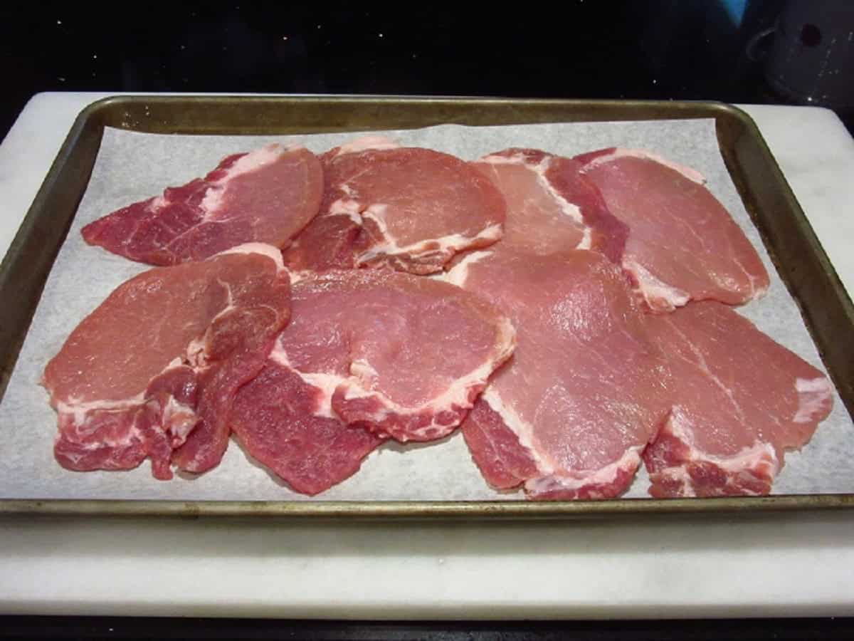 Pork cutlets on a baking sheet.