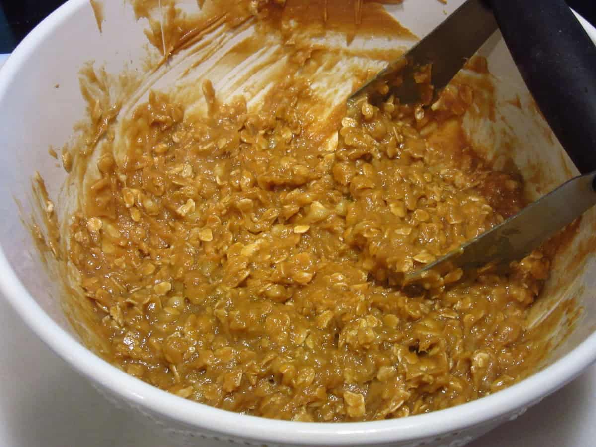 Cookie dough in a bowl with a pastry blender.