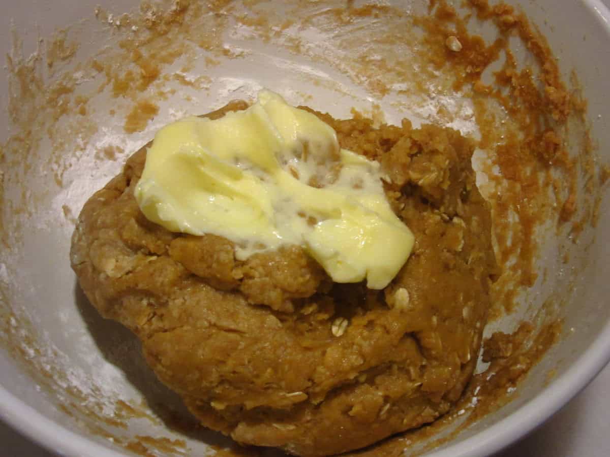Softened butter and raw cookie dough in a bowl.