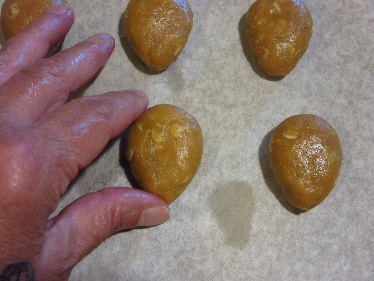 A hand shaping acorn cookie dough.