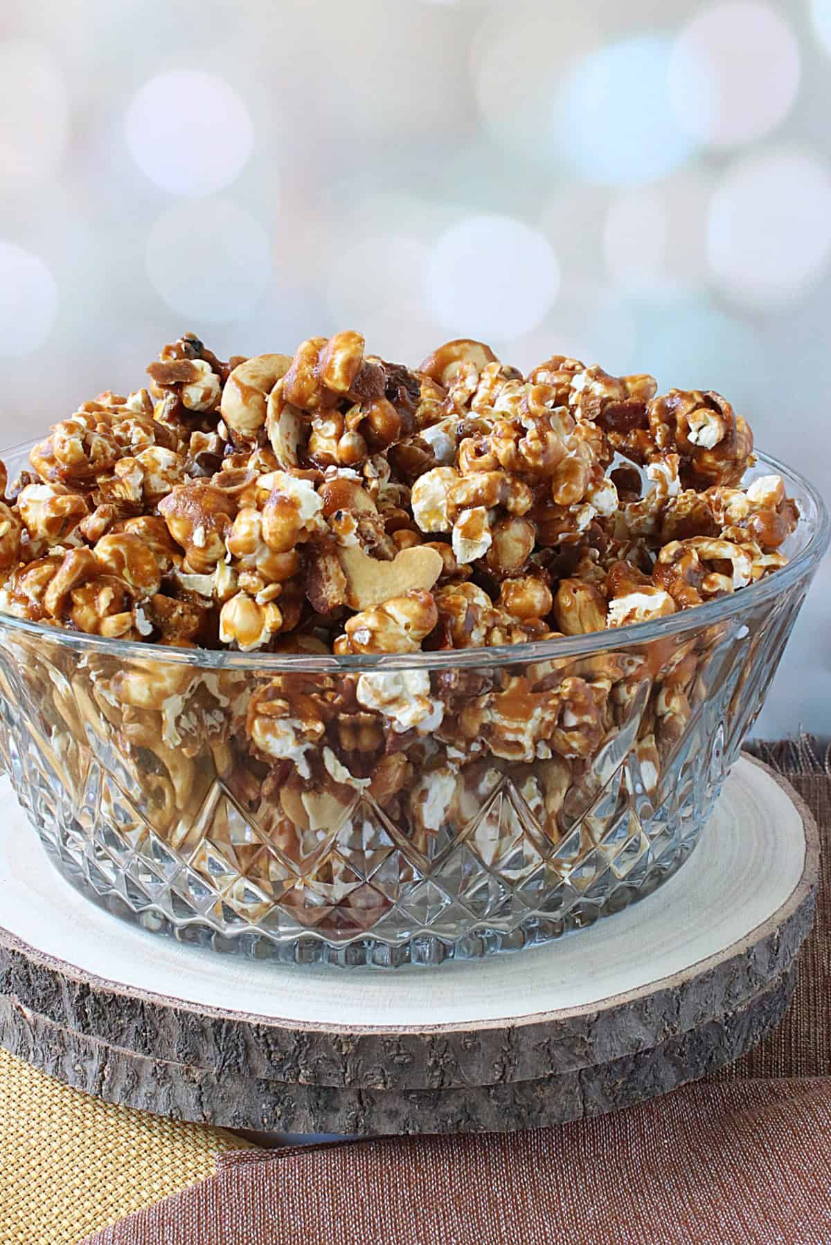 A glass bowl filled with delicious looking Caramel Corn with Cashews and Bacon.