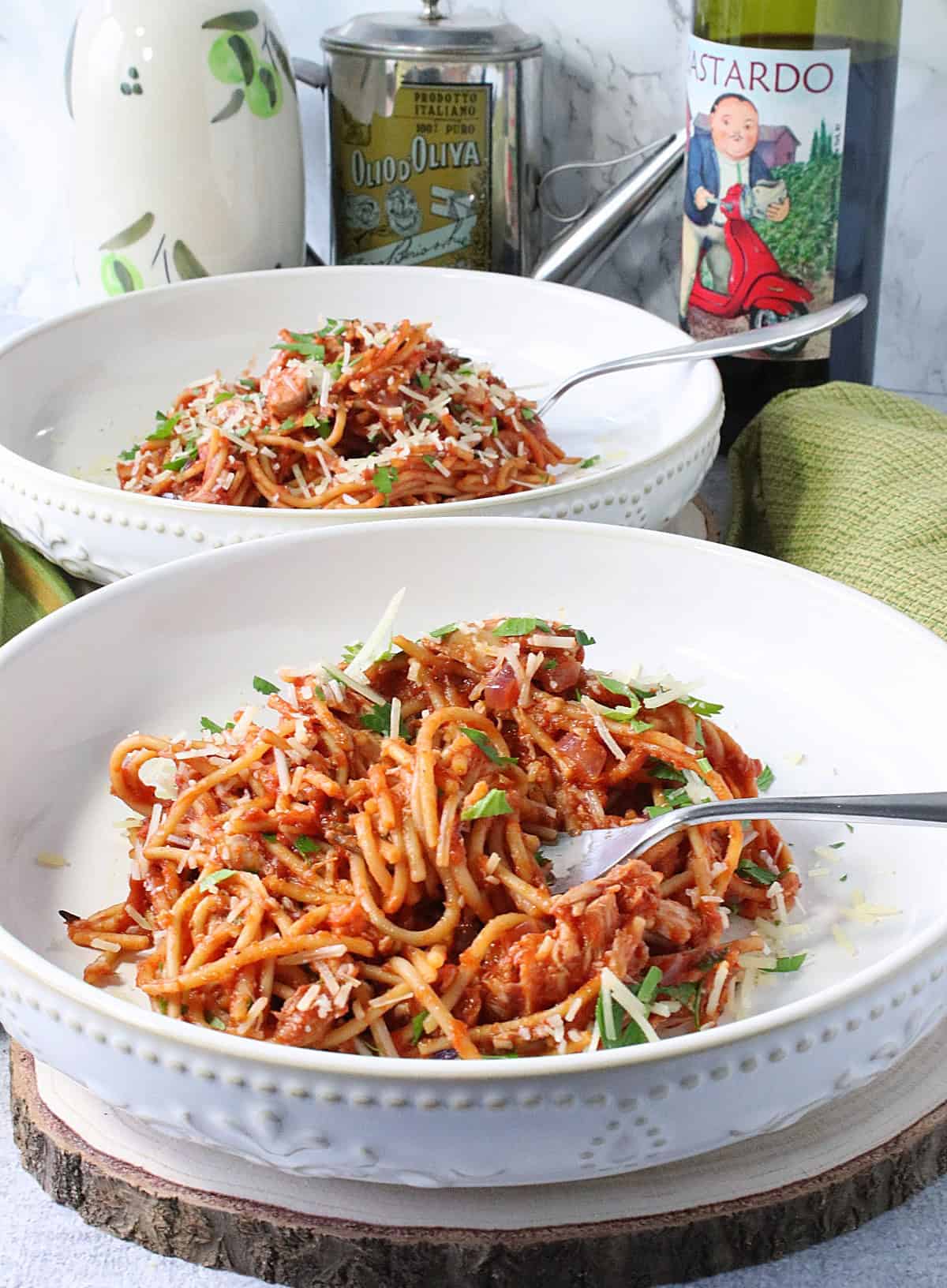Two inviting bowls of French Spaghetti topped with Parmesan cheese and chopped parsley.