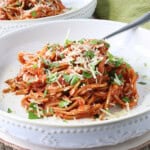A delicious serving of French Spaghetti in a white bowl with a fork.