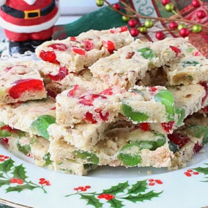Red and green cherry slices cookies on a pretty holly berry plate.