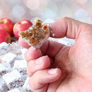 A hand holding an Old-Fashioned Apple Chew Candy with a bite taken out.