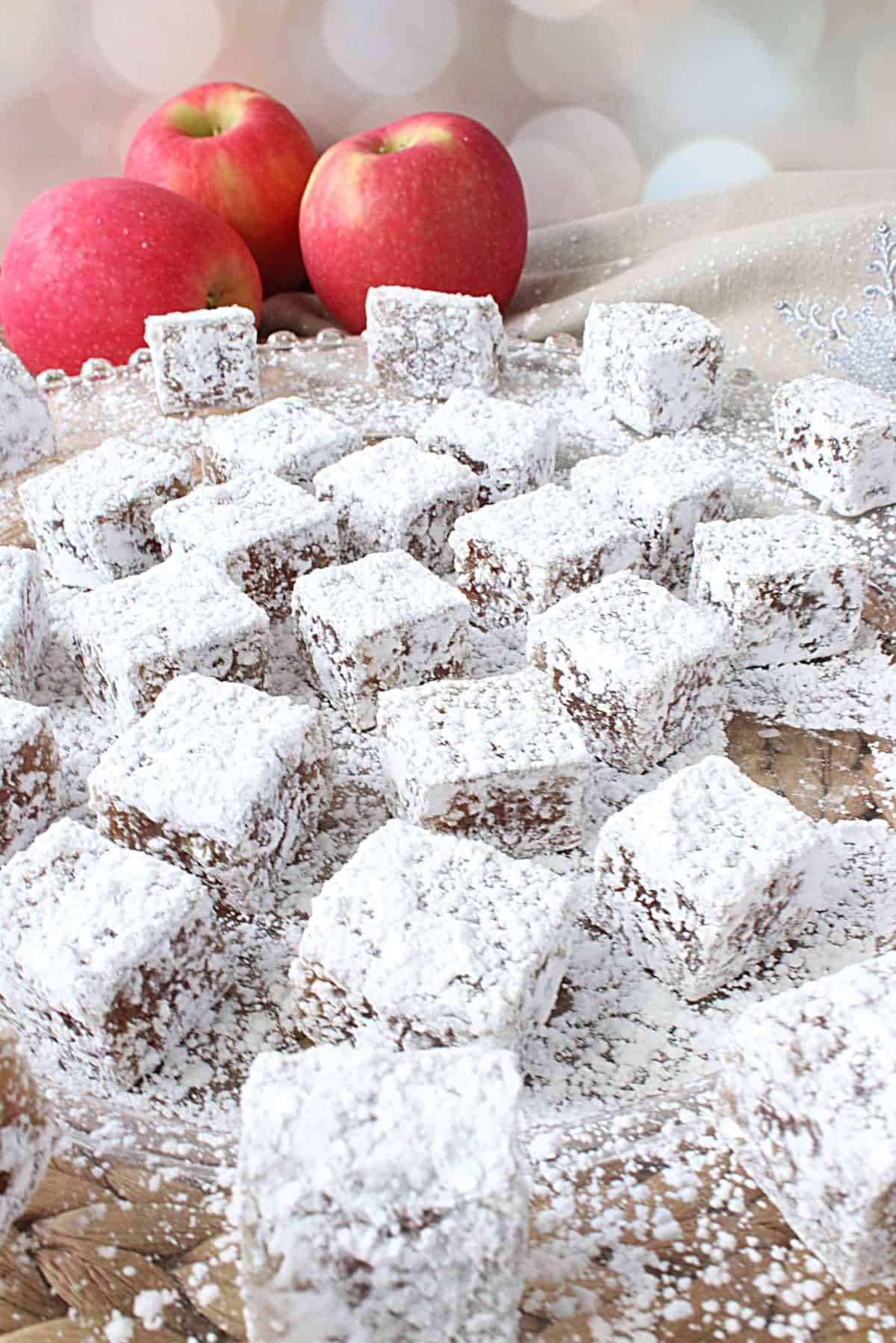 A glass plate filled with confectioner's sugar dusted Old-Fashioned Apple Chews candy.