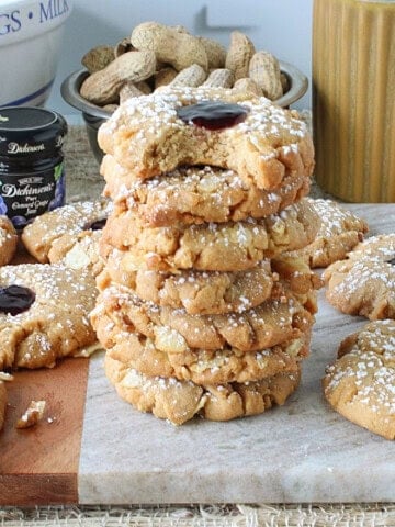A stack of Peanut Butter and Jelly Potato Chip Cookies dusted with confectioners sugar.