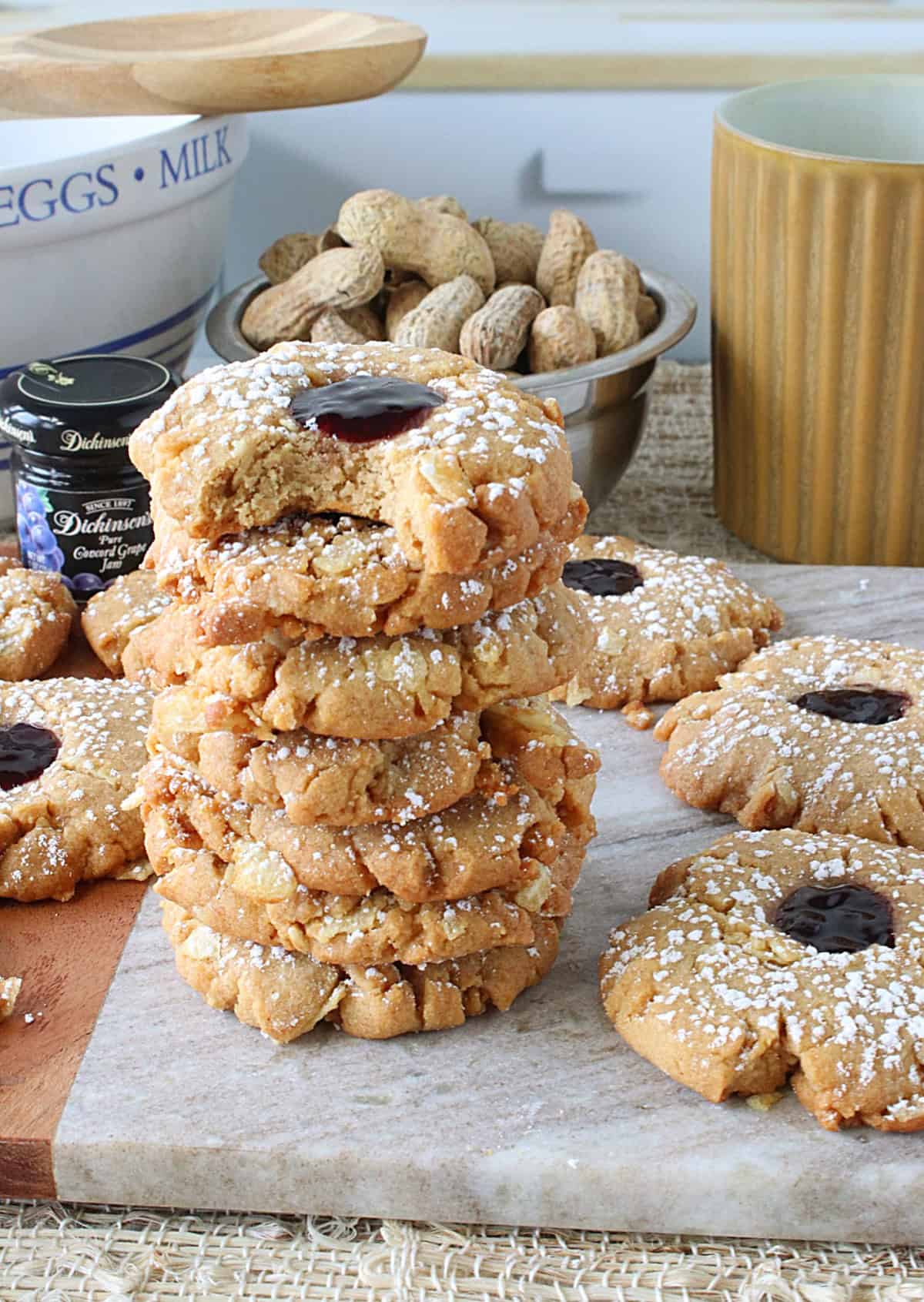 A stack of Peanut Butter and Jelly Potato Chip Cookies and the top one has a bite taken out of it.