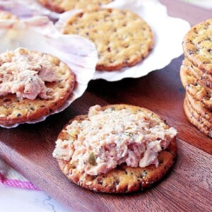 A cracker piled high with baked salmon salad spread.