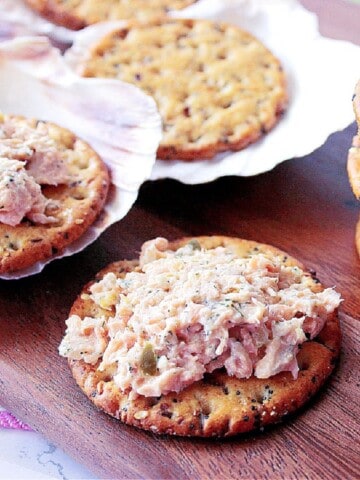 A cracker piled high with baked salmon salad spread.