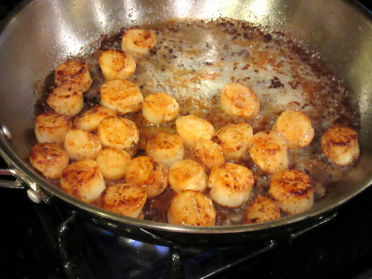 Caramelizing scallops in a large skillet.