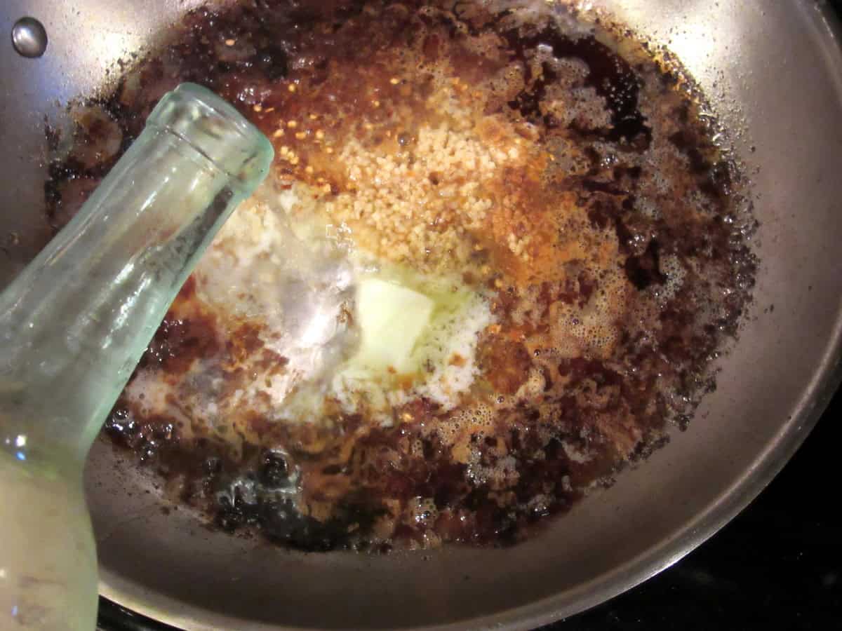 Deglazing a skillet with white wine.