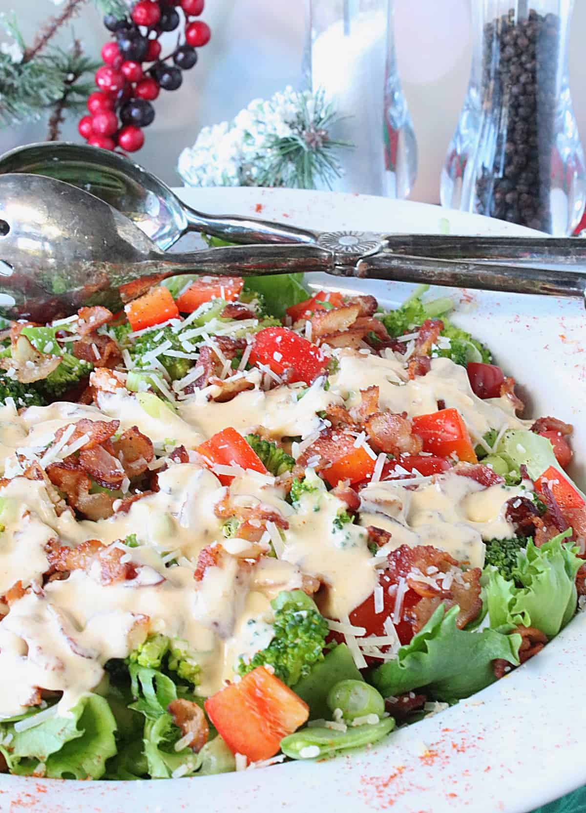 A Red and Green Christmas Salad topped with dressing and cheese.