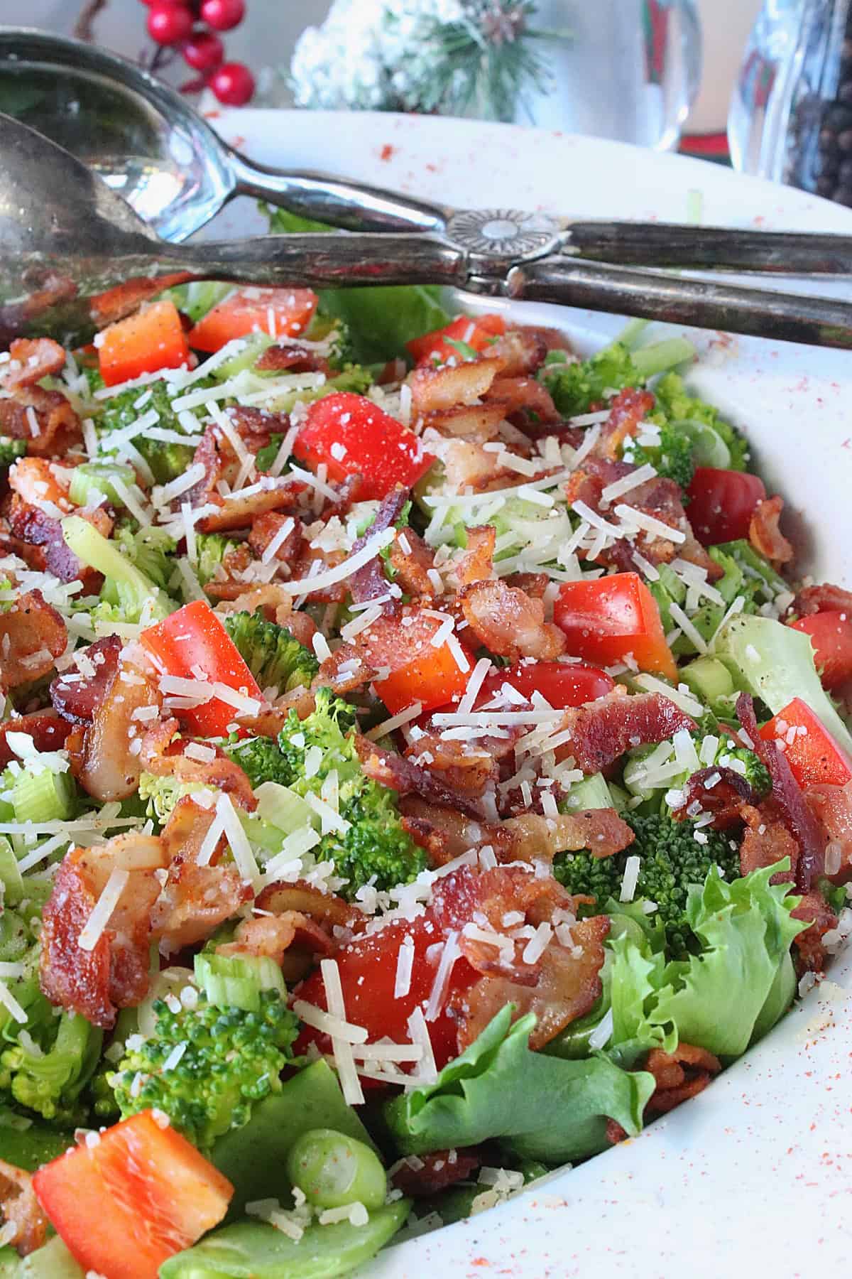 A colorful red and green Christmas Salad with broccoli, cheese, and bacon.