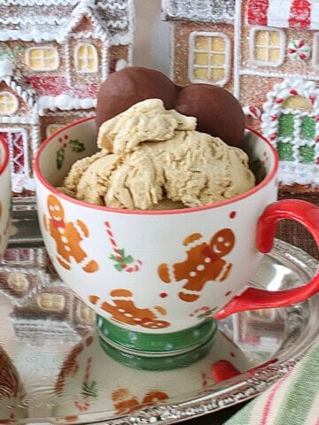 A cute cup with gingerbread men filled with gingerbread ice cream and a chocolate cookie.