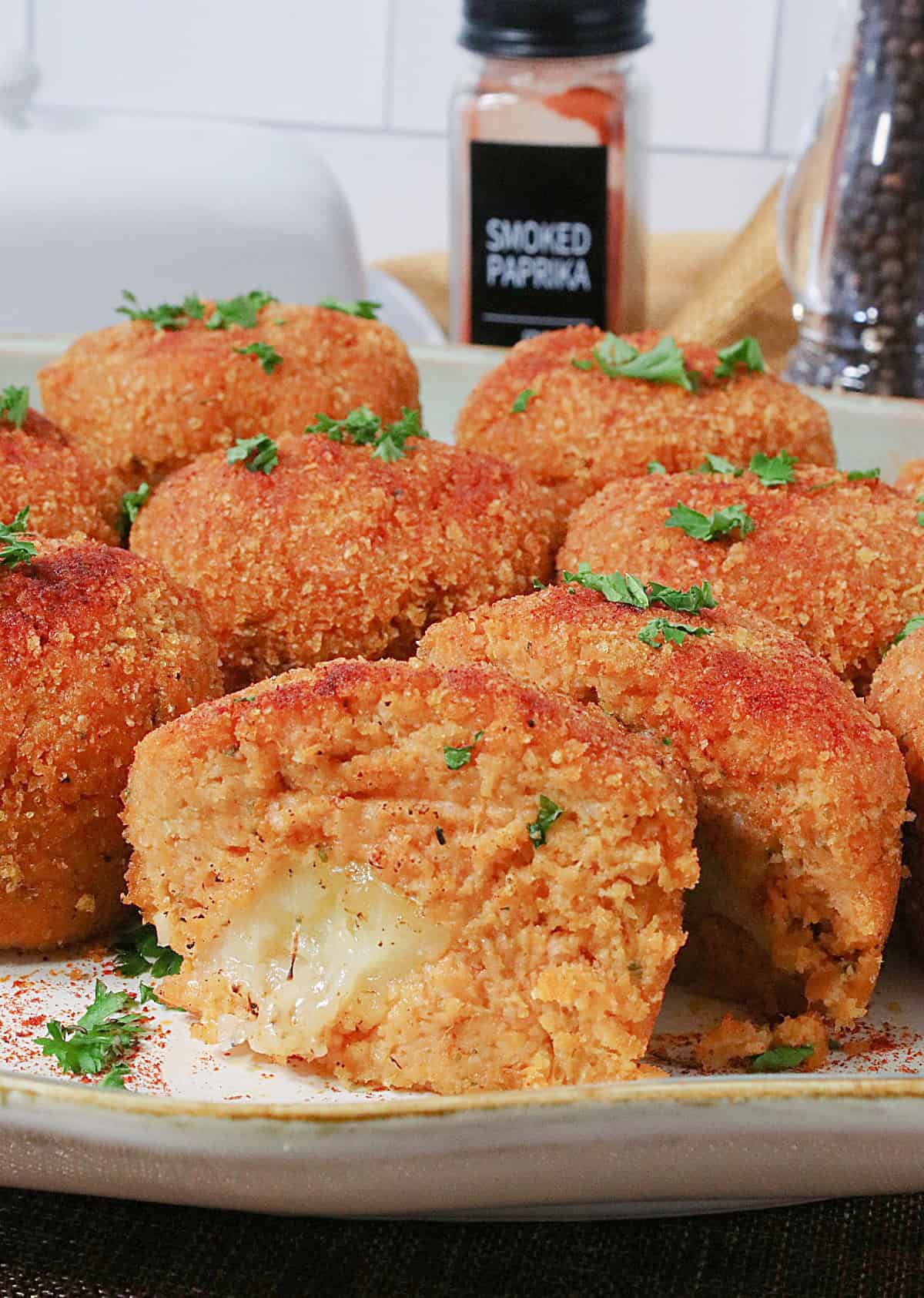 A mashed sweet potato croquette cut in half on a platter so you can see the inside.