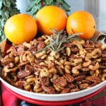 Cashews and Pecans in a bowl with rosemary and oranges.