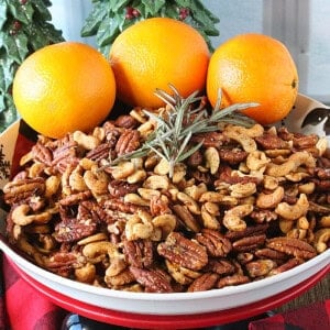 Cashews and Pecans in a bowl with rosemary and oranges.