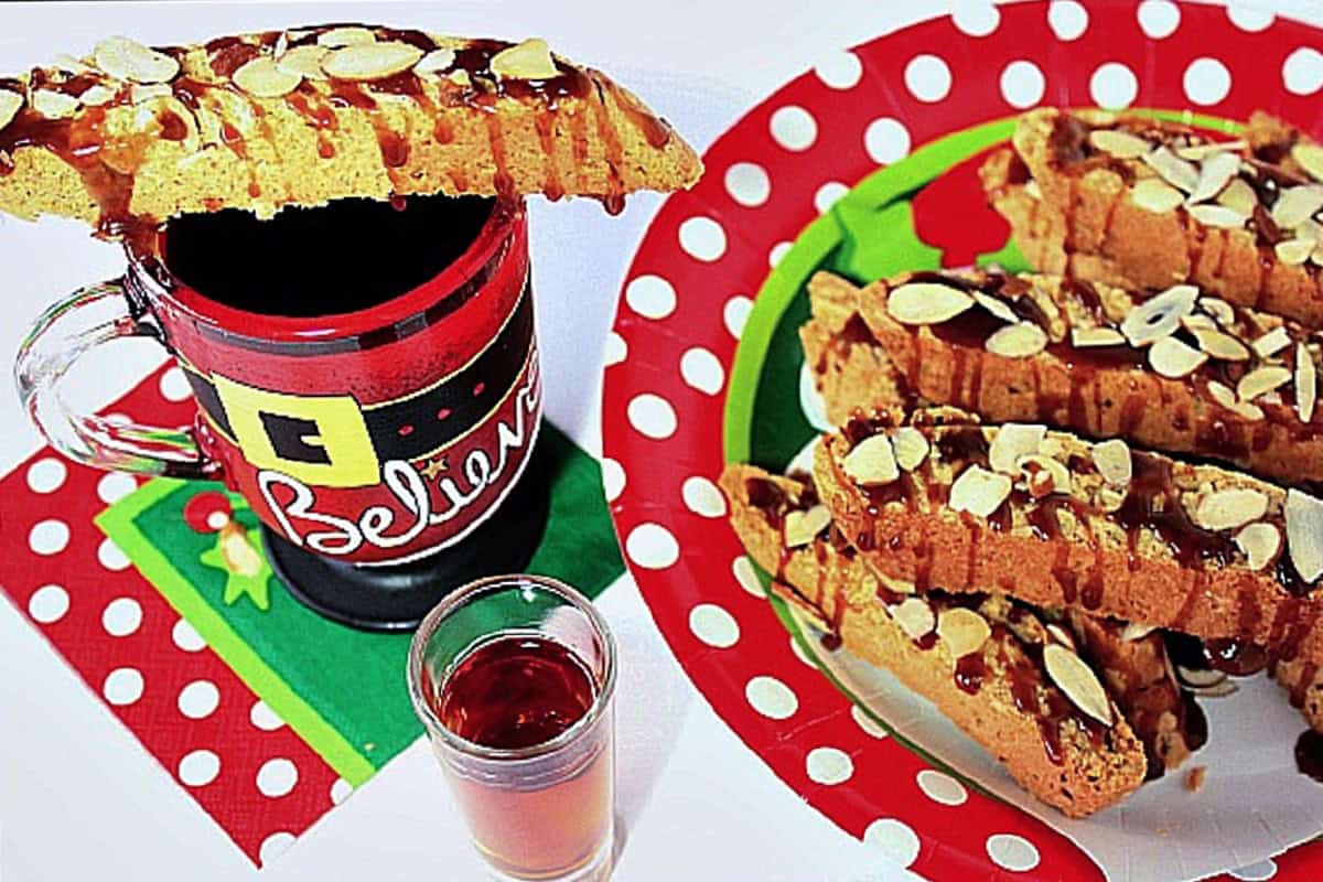 A biscotti cookie perched on top of a cute Santa mug cup of coffee.