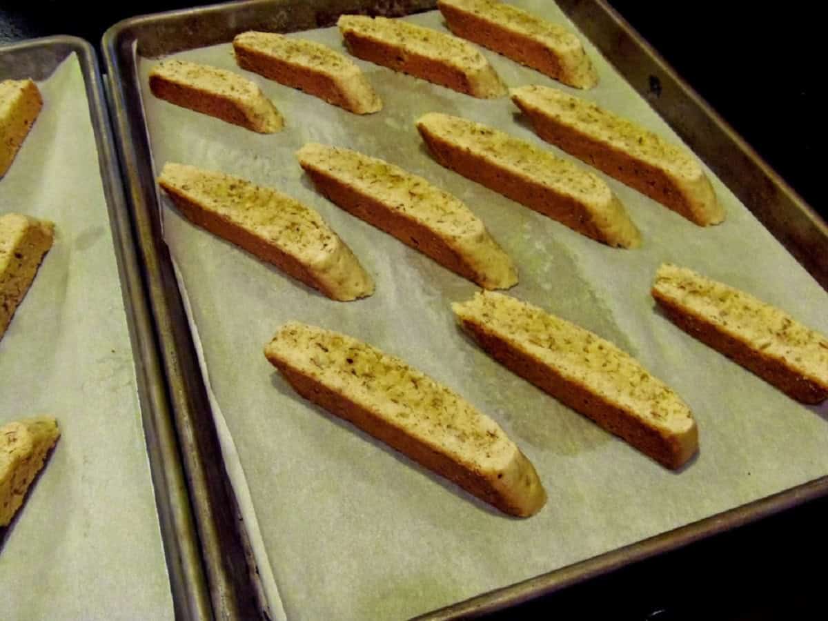 Sliced biscotti cookies on a baking sheet with parchment paper.