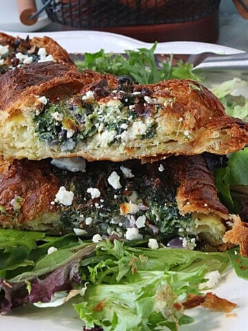 The inside of an air fryer croissant and egg breakfast sandwich with spinach and feta cheese.