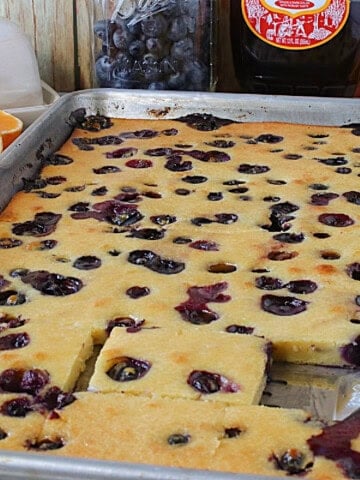 A blueberry and orange sheet pan pancake in a baking pan.