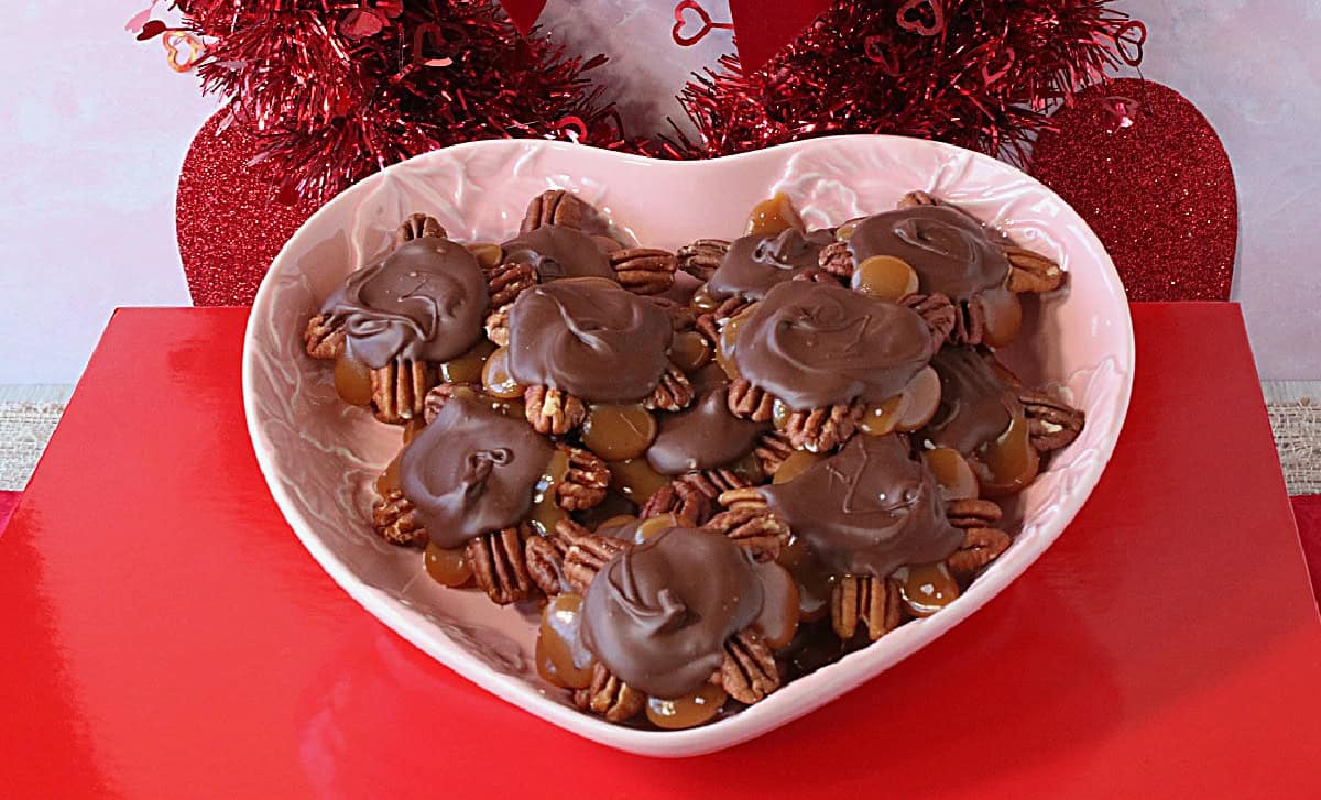 A Valentine's Day box with a dish of pecan turtles sitting on top.