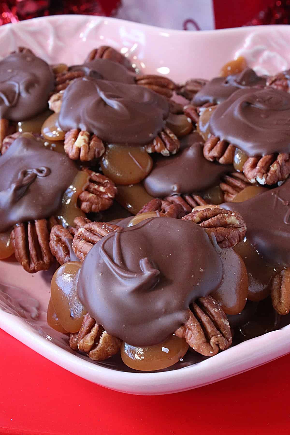 A closeup of a homemade caramel and chocolate pecan turtles.