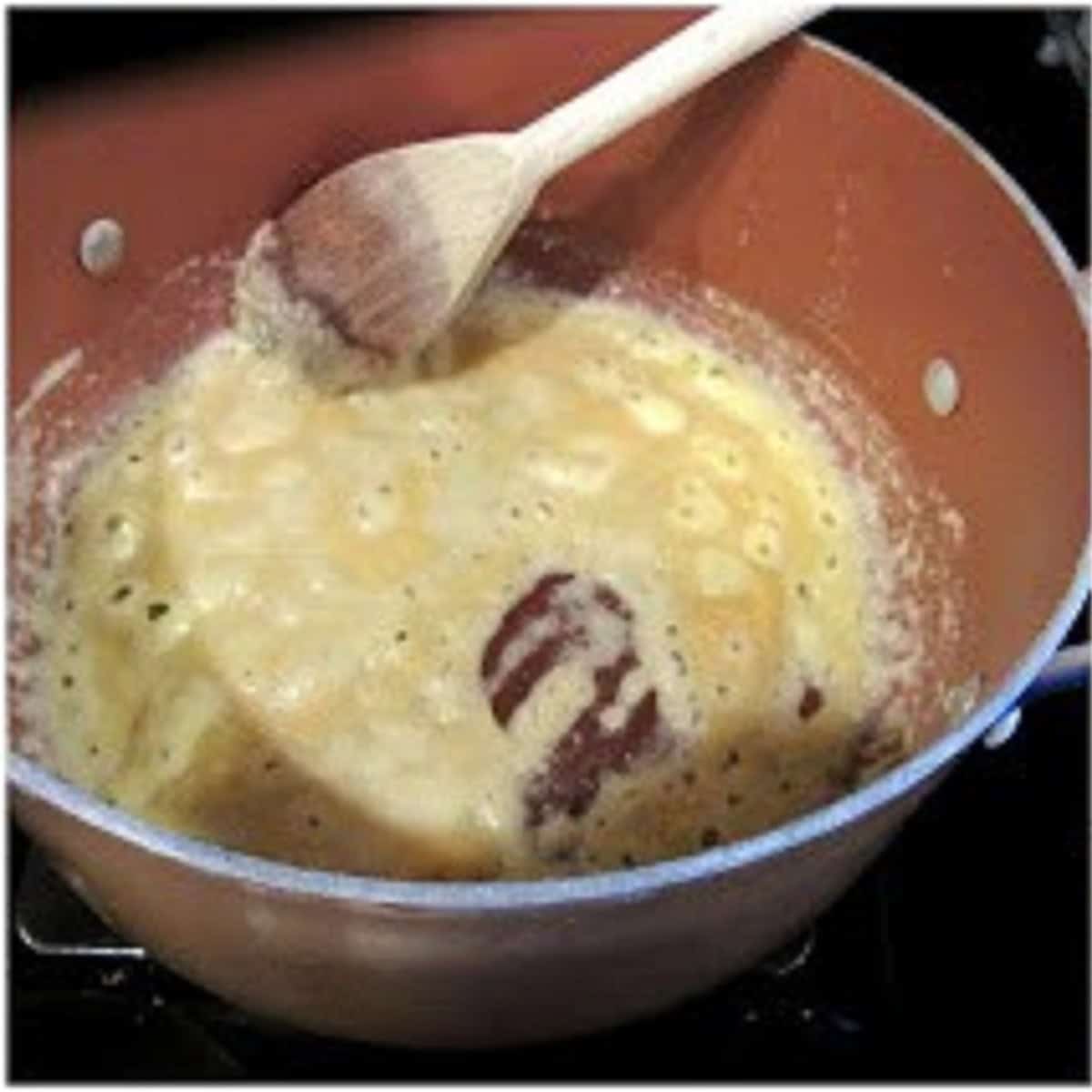 Flour and butter in a saucepan with a wooden spoon to make a roux.