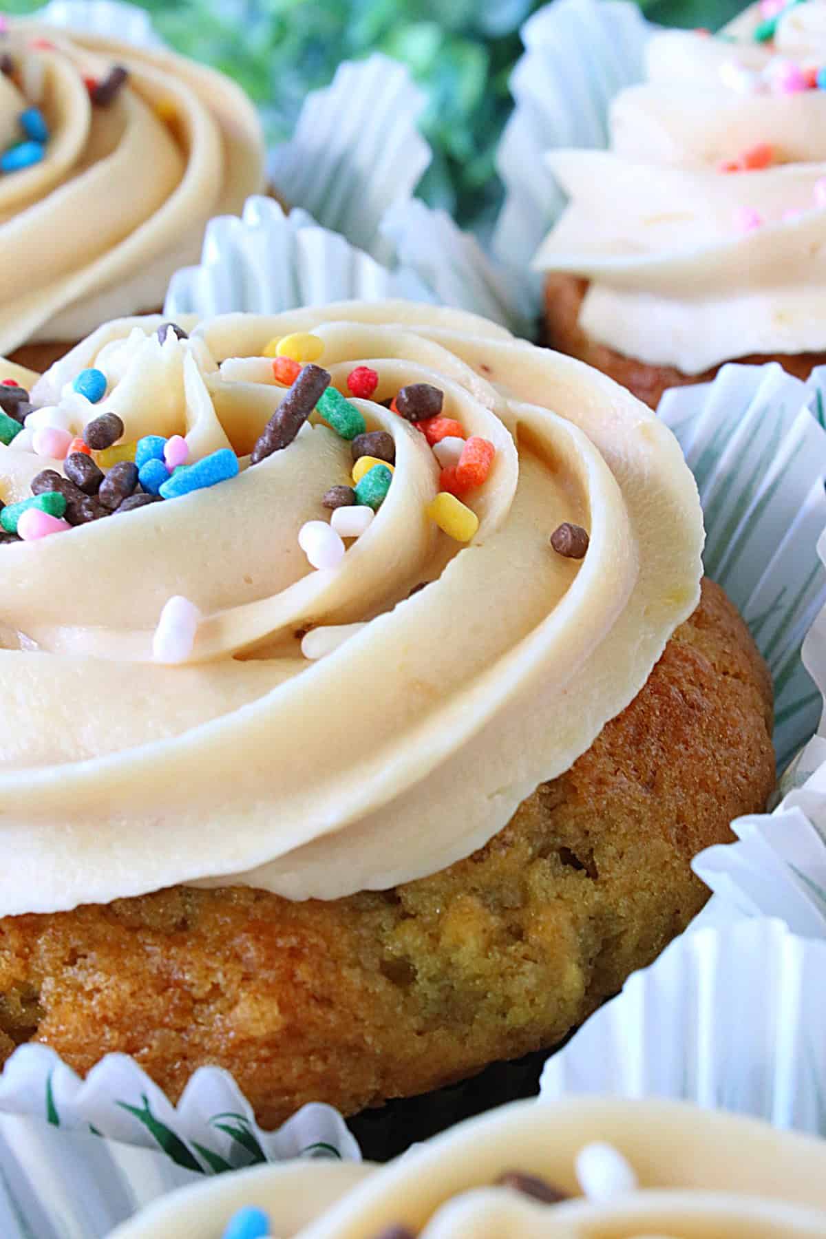 Banana buttercream frosting on a cupcake with sprinkles.
