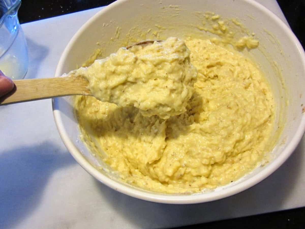 A mashed and shredded potato mixture in a white bowl.