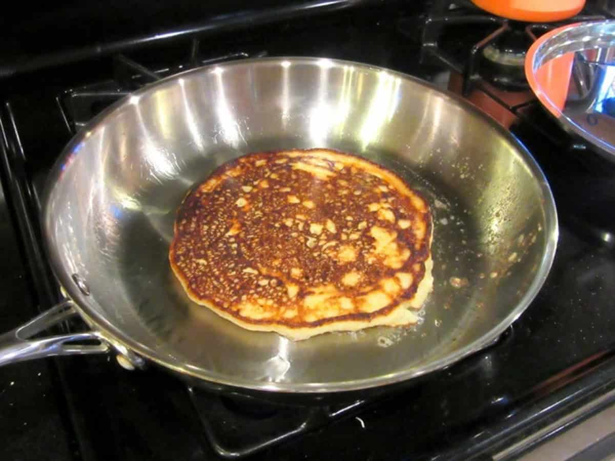 A golden brown potato pancake in a skillet.