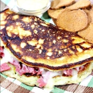 A stuffed Corned Beef Boxty on a plate with melted Swiss cheese.