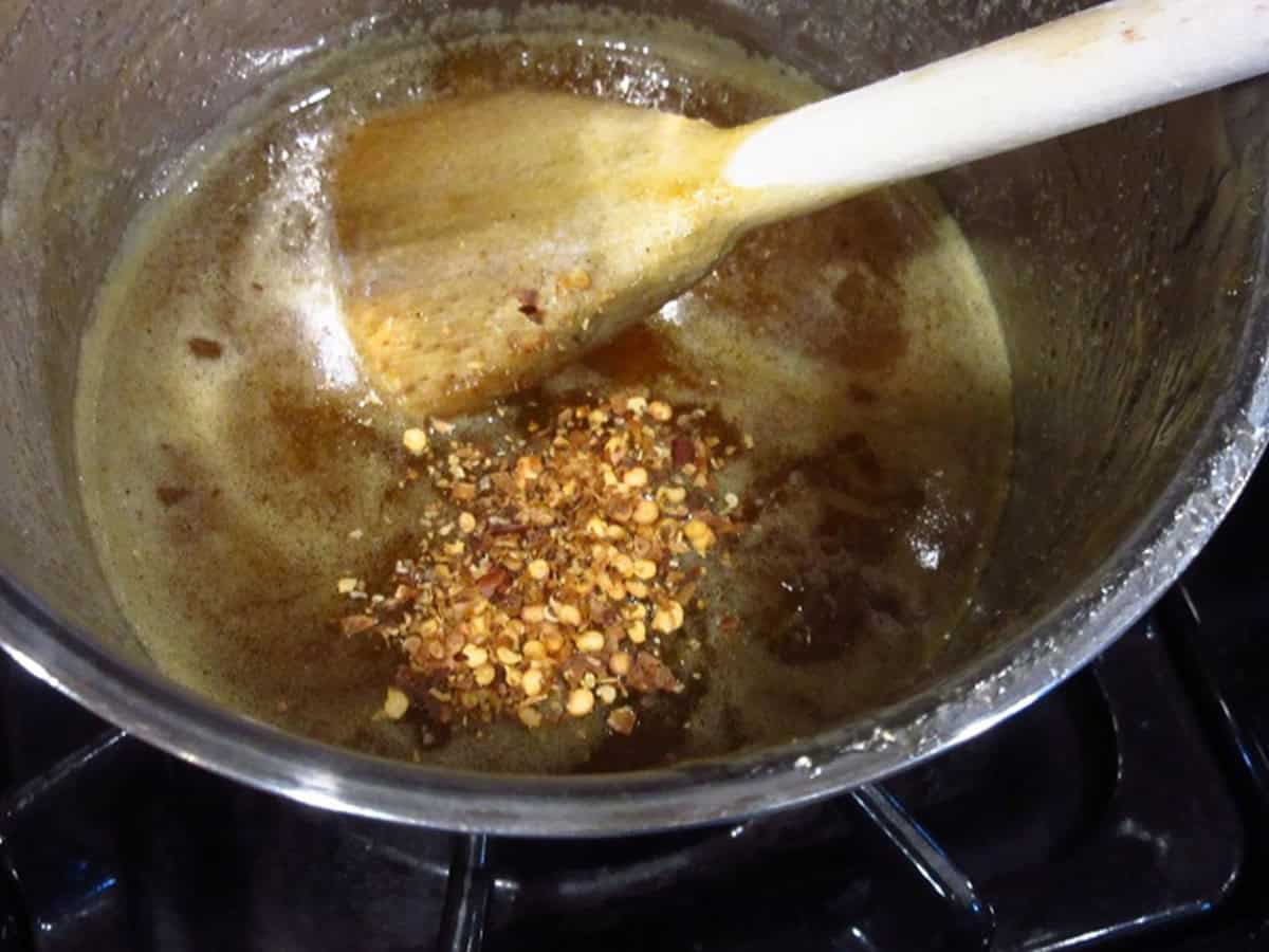 Red pepper flakes in a saucepan with a whiskey glaze.