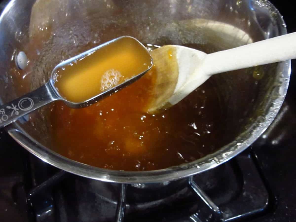 Vinegar being added to a saucepan with apricot glaze.