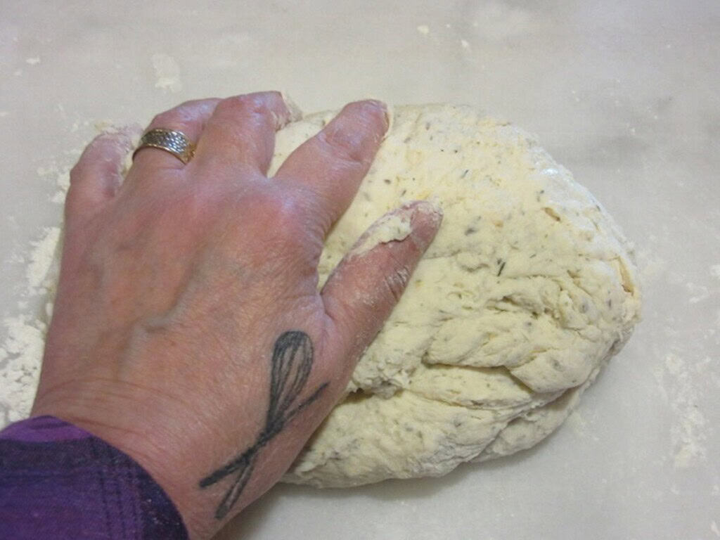 A hand kneading an Irish soda bread dough.