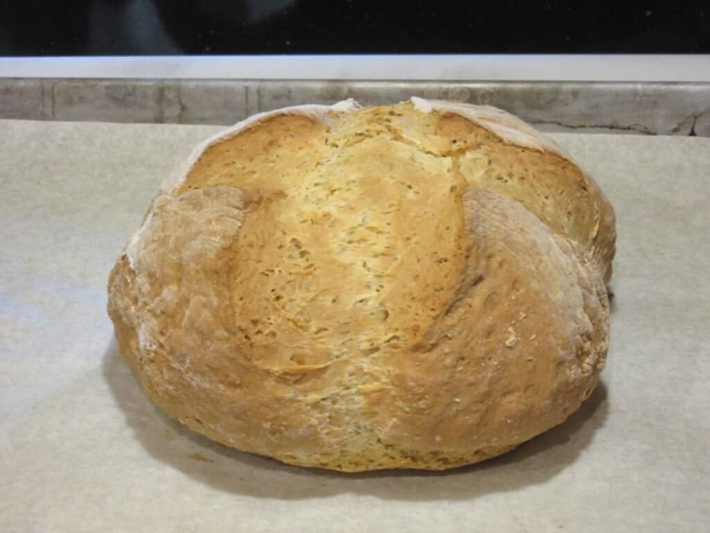 A freshly baked loaf of Irish soda bread on a baking sheet.