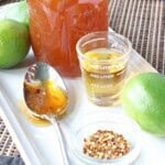 A spoon and a shot glass on a plate with Irish Whiskey Glaze.