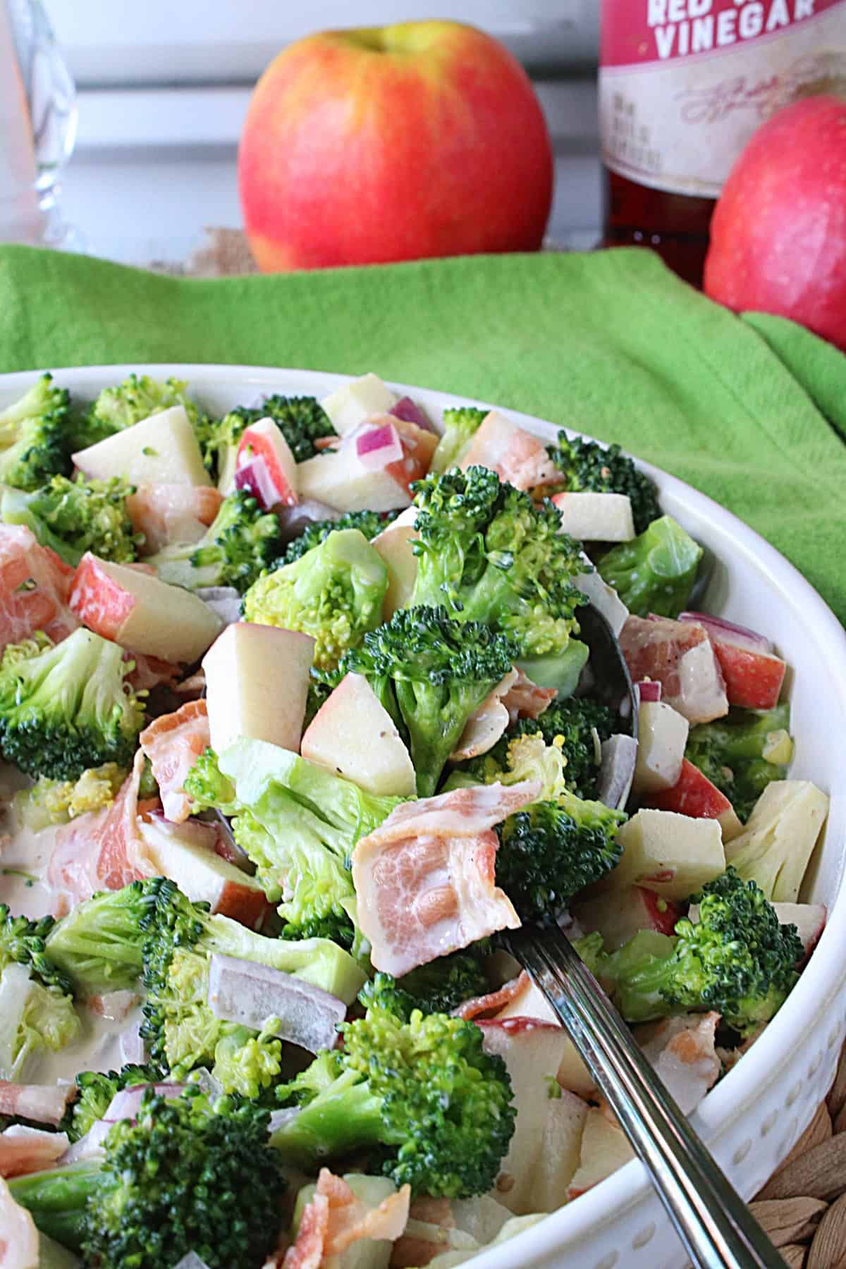 A beautiful chilled broccoli salad with pieces of bacon, onion, and apple.