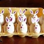 Carton full of fully decorated hard-boiled bunny eggs.