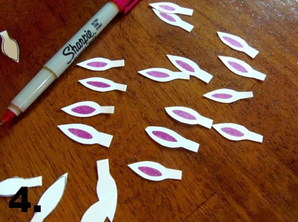 Bunny ear cutouts with purple ears being drawn on them.