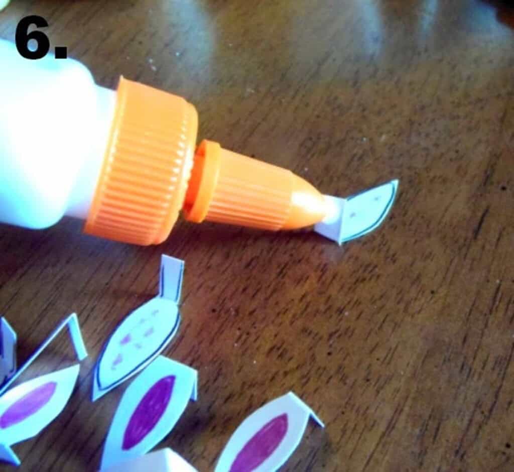 Glue being added to the flap of a paper bunny ear.