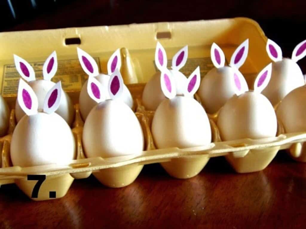 Hard boiled eggs in a carton with bunny ears attached.