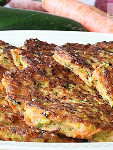 Delicious golden brown zucchini carrot fritters on a platter.